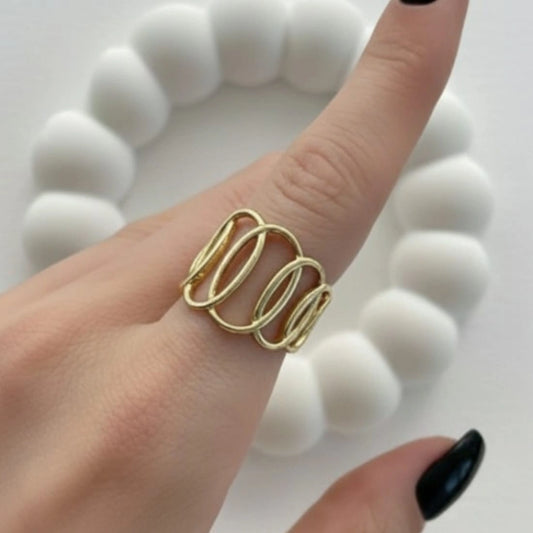 Gold ring on a finger with a white textured background
