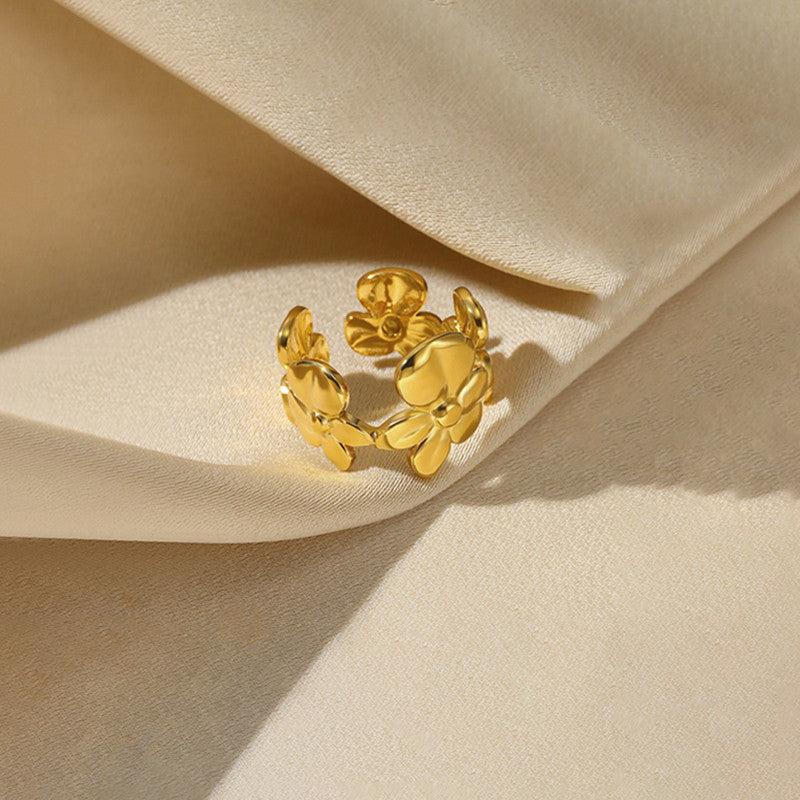 Gold floral ring on a beige fabric background